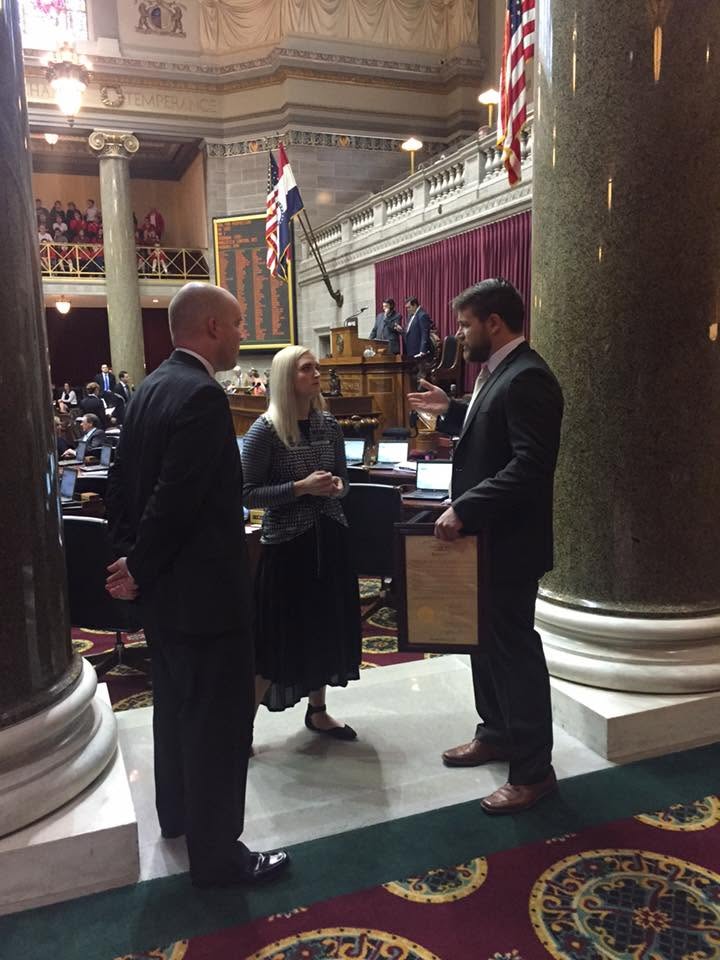 Shawn Lee presenting a plaque during a formal recognition in a legislative chamber